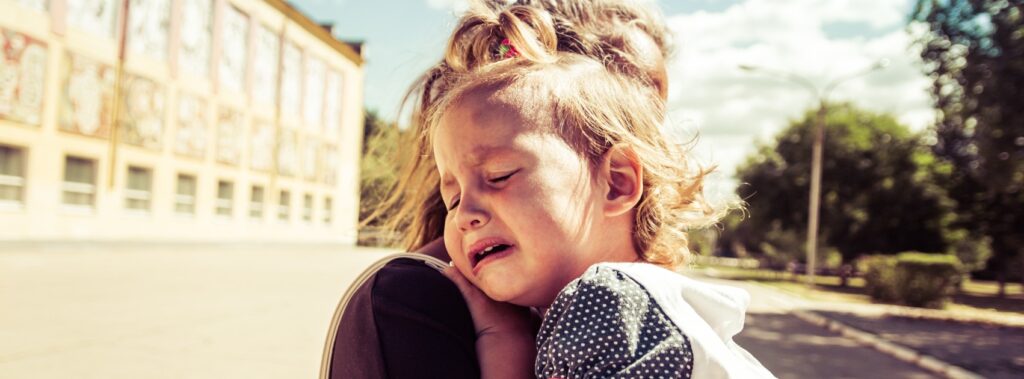 una mamma abbraccia la sua bambina che piange in crisi emotiva
